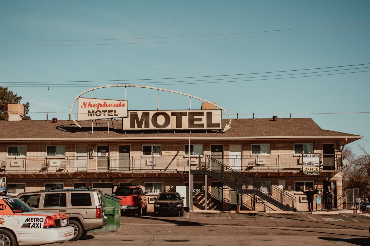 A nostalgic view of Shepherd's Motel with cars parked in front under a clear blue sky.